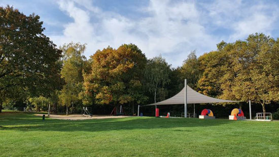 Liegewiese mit Spielplatz im Hintergrund